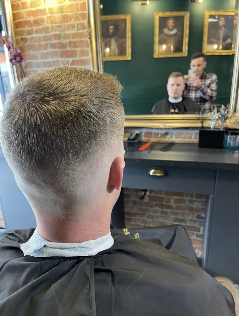 A fresh skin fade, seen from behind in the chair